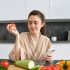 young-woman-orders-groceries-mobile-app-girl-bathrobe-sits-kitchen-with-vegetables_1258-198242